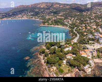 Panoramablick von oben auf das blaue Mittelmeer dea, Sandstrand der Stadt Agay, Sommerferienziel in der Nähe der roten Berge von Esterel, französische Riviera, Stockfoto