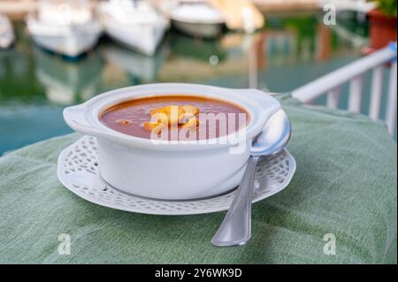 Hausgemachte leckere Fisch- oder Bisquesuppe mit Croutons im Freien und Blick auf Yachtboote und Häuser von Port Grimaud, französische Riviera. Lebensmittel von PR Stockfoto