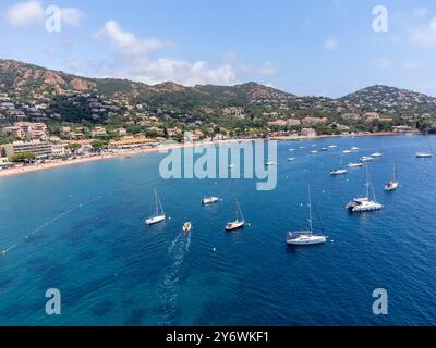 Panoramablick von oben auf das blaue Mittelmeer dea, Sandstrand der Stadt Agay, Sommerferienziel in der Nähe der roten Berge von Esterel, französische Riviera, Stockfoto