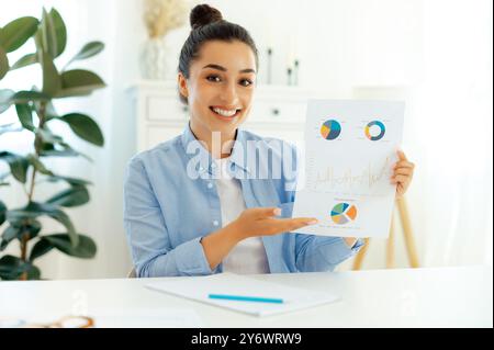 Online-Geschäftstreffen. Selbstbewusste junge Frau, ceo, Finanzberater, sitzen am Schreibtisch, schauen auf die Webkamera, erklären Geschäftsbericht, haben Online-Geschäftstreffen, lächeln Stockfoto
