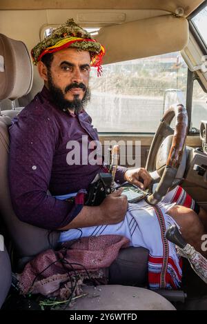 SAUDI-ARABIEN - 24. NOVEMBER 2021: Ein einheimischer Mann trägt einen traditionellen Blumenkopfschmuck in seinem Auto im Südwesten Saudi-Arabiens Stockfoto