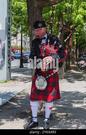 Dudelsack spielt im Frühling unter einem Baum in Old Montreal, Quebec, Kanada. Stockfoto