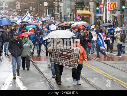 San Francisco, KALIFORNIEN - 03. März 2024: Unbekannte Teilnehmer an einem Marsch gegen Antisemitismus auf der Market Street zum Civic Center. Marschieren im Regen. Stockfoto