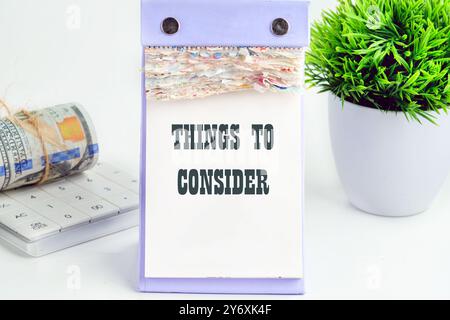 Geschäftskonzept, um etwas sorgfältig zu überdenken. Wortschreibung Text DINGE, DIE in einem Desktop-Kalender auf hellem Hintergrund ZU BEACHTEN SIND Stockfoto