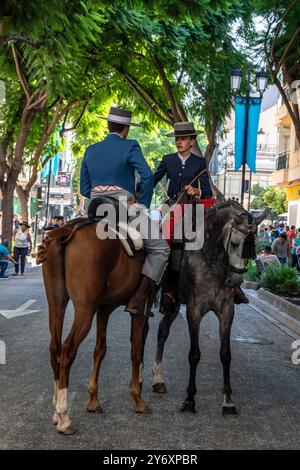 Gruppe von Reitern in traditioneller andalusischer Tracht, die während der Feier des Pferdetages durch die Straßen von Fuengirola reiten. Stockfoto