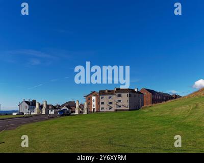 Der säulenförmige Eingang zum ArbroathÕs Victoria Park mit den Waterfront Cottages in der South Street sowie Apartments aus umgebauten Lagerhäusern auf Hil Stockfoto