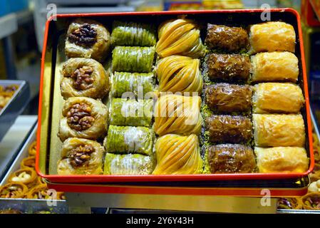 Geschenkset türkischer Süßigkeiten: Eine offene Schachtel mit fünf Arten von frischem Nussbaklava. Traditionelles orientalisches Dessert in einem Schaufenster eines Süßwarengeschäfts Stockfoto