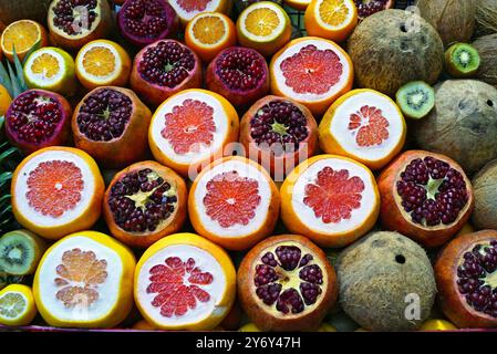 Ein heller Hintergrund aus Früchten: Kokosnüsse, geschnittene Granatäpfel, Grapefruits und Orangen. Verschiedene frische Früchte für die Herstellung von natürlichen Säften in der Istiklal Street Stockfoto