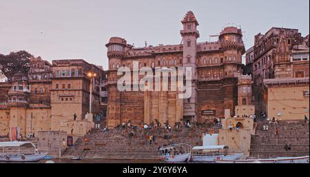 Varanasi, Indien. Allgemeiner Blick Vom Vergnügungsboot Auf Sarvesvara Und Digpatia Ghat. Violetter Sonnenuntergang Am Abend. Viele Boote Vertäuten Am Ganga River Stockfoto