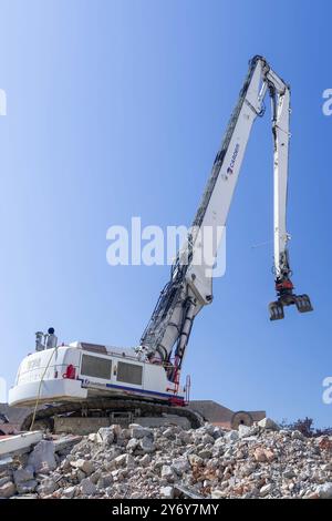 Blick auf einen weißen Raupenbagger Liebherr R 974 C, der einen Bürokomplex abriss. Stockfoto