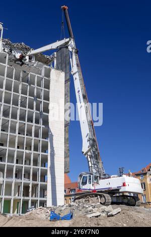 Blick auf einen weißen Raupenbagger Liebherr R 974 C, der einen Bürokomplex abriss. Stockfoto