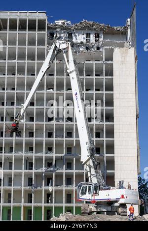 Blick auf einen weißen Raupenbagger Liebherr R 974 C, der einen Bürokomplex abriss. Stockfoto