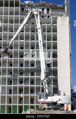 Blick auf einen weißen Raupenbagger Liebherr R 974 C, der einen Bürokomplex abriss. Stockfoto