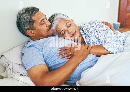 Kuscheln, schlafen und Seniorenpaar im Bett mit Ruhe für Liebe, Unterstützung und zusammen ein Nickerchen am Nachmittag. Müde, Leute und entspannen Sie sich mit einer Decke zu Hause Stockfoto