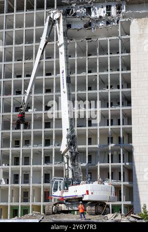 Blick auf einen weißen Raupenbagger Liebherr R 974 C, der einen Bürokomplex abriss. Stockfoto