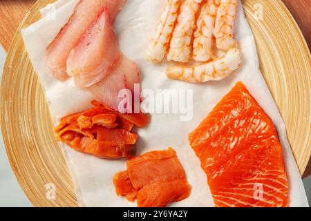 Frische Meeresfrüchte mit Lachs, Garnelen und verschiedenen Fischschnitten, die für kulinarische Zwecke zubereitet werden Stockfoto