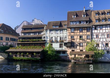 Straßburg, Frankreich - Blick auf das Tanner's Quarter mit farbigen Fachwerkhäusern und dem Fluss Ill und Reflexionen auf dem Wasser. Stockfoto