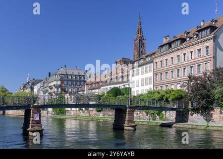 Straßburg, Frankreich - die Abreuvoir-Fußgängerbrücke über den Ill mit alten Gebäuden und im Hintergrund der Glockenturm des Straßburger Doms. Stockfoto