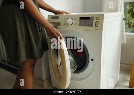 Laden der Waschmaschine in der modernen Waschküche Stockfoto