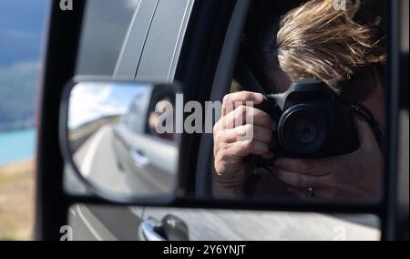Frau fotografiert sich von einem Fahrzeugspiegel Stockfoto