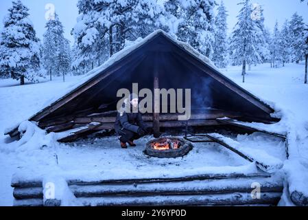 Holzkamin (Lavu auf Finnisch) auf dem Berg Ounasvaara in Rovaniemi, im Winter schneebedeckt (Lappland, Finnland) ESP: Cobertizo de madera en Rovaniemi Stockfoto