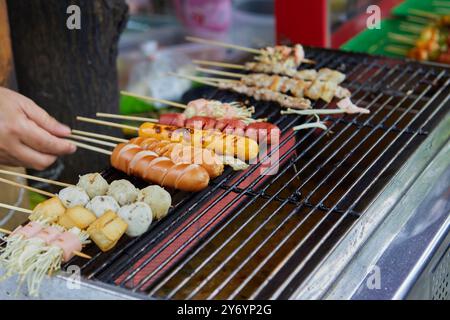 Nahaufnahme des Handgrillspießes Wurst und Fleischbällchen auf dem Grill Stockfoto