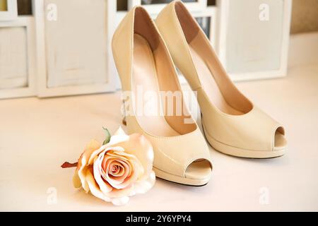 Hochzeit Schuhe mit hohen Absätzen stehen auf eine weiße Kommode auf dem Hintergrund der Bilderrahmen Stockfoto
