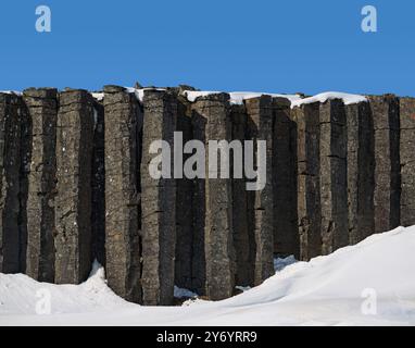 Felsformationen von Basaltsäulenklippen im Schnee Stockfoto