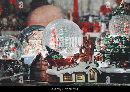 Weihnachtsmarkt mit verschiedenen Arten von Weihnachtsdekoration zum Verkauf. Schneekugel mit Weihnachtsmotiv. Stockfoto