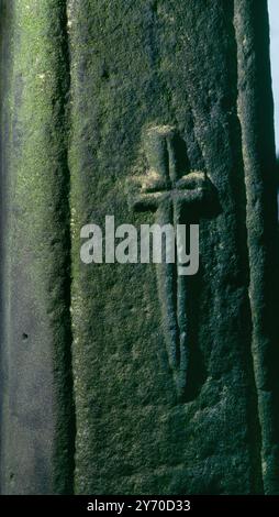 Ein lateinisches Kreuz, das in Relief auf die E-Seite eines Kreuzschäfts im Kirchhof der Kirche von SS Mael and Sulien in Corwen, Denbighshire, Wales, Großbritannien, gemeißelt wurde. Stockfoto