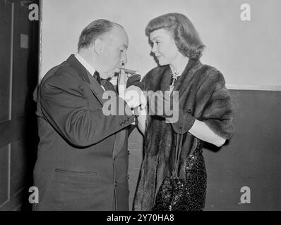 Schauspieler , Schauspielerinnen , Regisseure, Produzenten und andere Filmpersönlichkeiten von beiden Seiten des Atlantiks hatten gemeinsam einen Abend auf dem jährlichen Film Ball , der in der Royal Albert Hall in London stattfand . Die Funktion war zur Unterstützung des Cinematograph Trade Benevolent Fund . DAS BILD ZEIGT:- die US-amerikanische Schauspielerin Jane Wyman stellt dem Regisseur ALFRED HITCHCOCK ein Licht zur Verfügung , Miss Wyman entschied sich , den Bootszug zu verpassen , um den Ball zu besuchen und mit dem Auto nach Southampton zu fahren . September 1949 Stockfoto