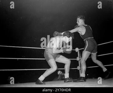 SHILED BOXING France hält das Britannia-Schild mit insgesamt 110 Punkten für ein drittes Jahr in Folge, nachdem es im Boxwettbewerb im Empire Pool, Wembley, London, Zweiter hinter Großbritannien wurde. Der Britannia Shield Athletic Competition, der an die Schlacht von Großbritannien 1940 erinnert, ist eine jährliche Veranstaltung, an die sich Sportsportler aus Nationen wenden, die seit 1940 neben Großbritannien kämpften. DAS BILD ZEIGT:- PRIVAT C . Lunaud (links) Enten unter einer Linken von CPL N. Henderson (R.A.F.Brittain) im Boxfinale im Cruisergewicht, gewonnen von Lunaud. Stockfoto