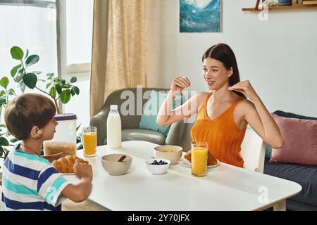 Ein kleiner Junge und seine Mutter teilen ein herzliches Frühstück voller visueller Kommunikation. Stockfoto