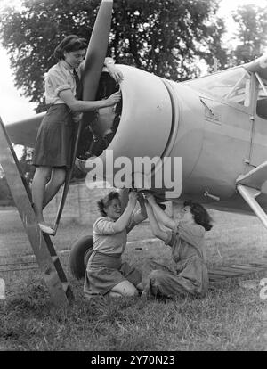 AIR GIRLS ' BANK HOLIDAY Girls, die behaupten könnten, die ungewöhnlichste Art gefunden zu haben, August Bank Holiday zu verbringen, sind Mitglieder der Junior Air Corpse der Frauen aus vielen Teilen des Landes, die ein vierzehntägiges Flugtraining-Camp auf dem weißen Waltham Flugplatz Berks besuchen. Die Mädchen haben alle einige Vorschulungen in der Flugzeugwartung erhalten und erweitern ihre Erfahrung, indem sie Ingenieuren des West London Aero Clubs helfen, Flugzeuge im White Waltham zu warten. DAS BILD ZEIGT:- Mädchen der W.J.A.C. arbeiten an einem Flugzeug im Weißen Waltham. Auf der Treppe ist Jean Riley von Birming Stockfoto