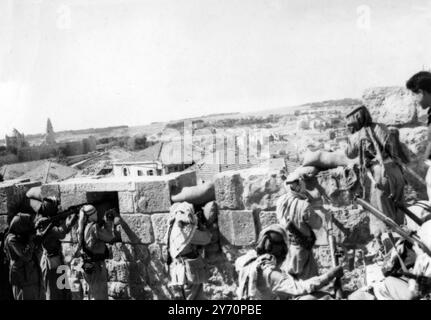 Dieses Bild, das heute aus Jerusalem auf dem Luftweg empfangen wurde , fällt mit der Nachricht des heftigen jüdischen Angriffs auf die Altstadt zusammen - der bisher schwerste. Von Dienstag um 10 Uhr bis 2 Uhr morgens bemühte sich Haganahs Crack-Palmach-Truppe, die Altstadt am Zion-Tor wieder einzudringen, aber sie wurden abgestoßen und der Angriff starb. Hier von oberhalb der Stadtmauern gesehen , wehrten Araber einen jüdischen Angriff von den umkämpften alten Stadtmauern Jerusalems ab . 3. Juni 1948 Stockfoto