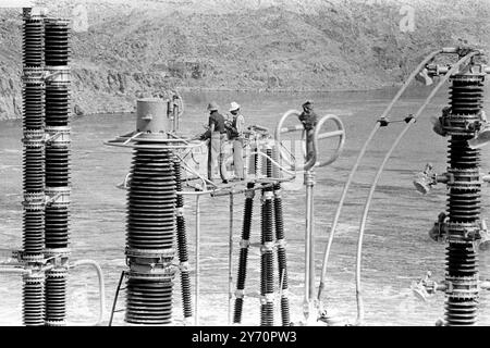 ASSUAN HIGH DAM NÄHERT SICH DER FERTIGSTELLUNG ASSUAN, ÄGYPTEN; Aus der Vogelperspektive sehen Ingenieure, die an Stromleitungen am Assuan High Dam arbeiten. 28. Januar 1968 Stockfoto