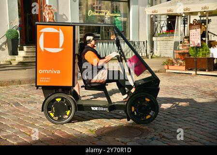 Pedalantrieb Omniva Postzustellung EV Fahrzeug Vok Bikes mit Paketaufbewahrung, Lieferung in der Altstadt auf Kopfsteinpflasterstraßen Tallinn, Estland. Stockfoto