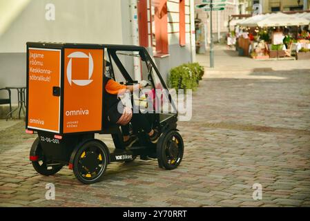 Pedalantrieb Omniva Postzustellung EV Fahrzeug Vok Bikes mit Paketaufbewahrung, Lieferung in der Altstadt auf Kopfsteinpflasterstraßen Tallinn, Estland. Stockfoto