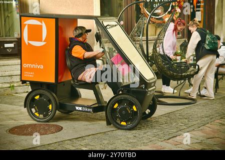 Pedalantrieb Omniva Postzustellung EV Fahrzeug Vok Bikes mit Paketaufbewahrung, Lieferung in der Altstadt auf Kopfsteinpflasterstraßen Tallinn, Estland. Stockfoto