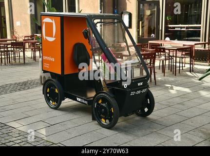 Pedalantrieb Omniva Postzustellung EV Fahrzeug Vok Bikes mit Paketaufbewahrung, Lieferung in der Altstadt auf Kopfsteinpflasterstraßen Tallinn, Estland. Stockfoto