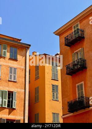 Alte Wohngebäude mit warmen Fassaden und schmiedeeisernen Balkonen. Authentische mediterrane Atmosphäre in einer europäischen Altstadt Stockfoto