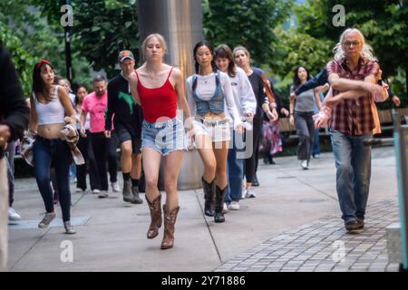 New Yorker und Besucher tanzen im Bella Abzug Park in New York am Mittwoch, den 26. September 2024 während des Line Dancing Workshops im Park. Am Abend zogen die Tänzer ihre Stiefel an und tanzten einen Sturm in der Werkstatt der Big Apple Ranch. Der Tanz ist nur eine der vielen Aktivitäten, die die Hudson Yards Hells Kitchen Alliance im Bella Abzug Park durchführt. (© Richard B. Levine) Stockfoto