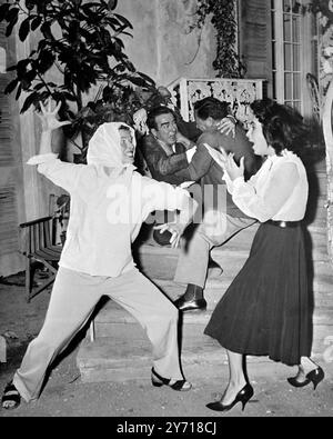 Shepperton Studios , London : Talente im Wert Einer Million Dollar explodieren am Set der Shepperton Studios . Erkennen Sie die Kämpfer? Es ist Katharine Hepburn (links), kurz davor, ihre Finger in das wehende Gesicht von Elizabeth Taylor zu kratzen. Im Hintergrund wird der blaue Mord von Star Montgomery Clift (links) und Regisseur Joseph Mankiewicz verprügelt. Es kam alles, als Zeitungsberichte besagten, dass die beiden führenden Damen von " Suddenty , Last Summer " , einem Tennessee Williams Drehbuch , sich fehden und klatschen. "Machen wir es richtig", sagte Liz, "Geben wir wirklich das Stockfoto