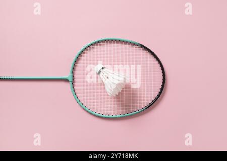 Weißer Federbadminton Shuttlecock und Badmintonschläger auf hellrosa Hintergrund. Blick von oben. Concept Racketsport. Freizeitspiele. Stockfoto