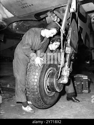 Die Luftmechaniker Sally Powell-Price, 20 von Newton Abbot, Devon (links) und Jocelyn Braddell, 19 von Cranleigh, Surrey, sahen ein Rad eines Marinekampferflugzeugs. Die Mädchen gehören zur Royal Naval Service Air Station Lee-on-Solent in Hampshire . Beide sind qualifizierte Flugzeugmechaniker. 14. März 1952 Stockfoto