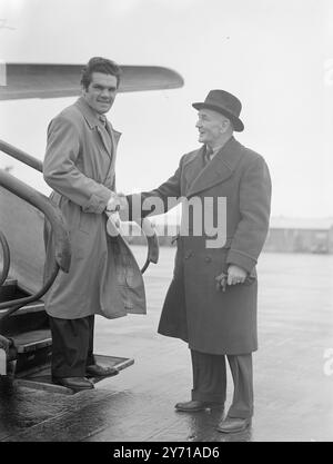 BOXER's ' BUSMAN's HOLIDAY ' Weltmeister im Leichtgewicht FREDDIE MILLS , der aufgrund der Zahnentfernung unter einem geschwollenen Gesicht leidet , verließ den Flughafen London für einen Urlaub in Südafrika , in dem wir den Bruce Woodcock gegen Johnny Ralph im Kampf beobachten werden . Er unterstützt Woodcock zum Sieg , wahrscheinlich durch einen Knock-Out . Nach seiner Rückkehr wird Mills Johnny Williams , das Leichtgewicht des Rugby , eine unserer besten Zukunftsperspektiven zurückbringen . DAS BILD ZEIGT :- LEBEWOHL FÜR EINE WEILE . FREDDIE MILLS (links) schüttelt TED BROADRIBB die Hand, als er den London Airport nach South AF verließ Stockfoto