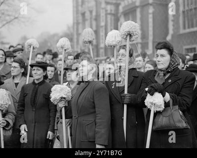 CHARS ON THE MARCH - MIT WISCHERN UND BÜRSTEN veranstalteten die Reinigerinnen von Regierungsbüros in London einen protestmarsch mit der Idee , die Aufmerksamkeit auf ihre Lohnerhöhungen zu lenken . Ihre Bemühungen richten sich an Sir Stafford Cripps . Sie fordern eine Erhöhung um 3 / 4 d pro Stunde . Unter der Leitung einer Pfeifenband marschierten die Putzfrauen mit Wischern und Bürsten durch die Londoner Straßen . Das Treffen wird eine Deputation wählen, die Sir Stafford Gripps trifft und die Lobby M. P's im Unterhaus. DAS BILD ZEIGT: CaMops und Gesichter - einige der Reinigungsfrauen, die Mopps klammerten, hören sich eine Ansprache an Stockfoto