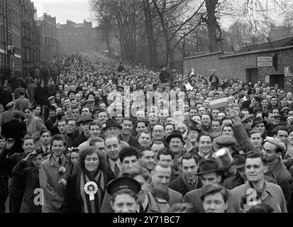 DIE BECHER "FANS" WARTETEN DIE GANZE NACHT - UND TROTZDEM KAMEN TAUSENDE AN. - - - - - Eine Menge enthusiastischer Unterstützer zitterte durch die Nacht vor dem Arsenal Ground in Highbury , London für den dritten Runde Cup '' Battle '' und London '' Derby '', als Arsenal auf Tottenham Hotspur trifft . - So viele Tausend warteten auf die Öffnung der Tore, dass man beschlossen hatte, dies um 10,30 Uhr morgens zu tun - und trotzdem kamen die Menschenmassen an . DAS BILD ZEIGT: DIE STRASSE ZUM POKAL Eine Menge Leute, die die Straße hinuntersausen und sich dem Arsenal Ground in Highbury nähern, drei Stunden vor dem Spielstand Stockfoto