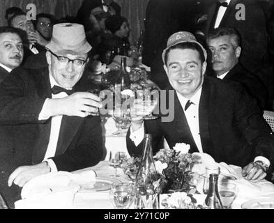 Die Gesamtsieger der diesjährigen Monte carlo Rallye, Paddy Hopkirk (rechts) und Beifahrer Henry Liddon, lassen sich während der Party für die Teilnehmer am Ende der Rallye am 27. Januar 1964 die Gläser anstoßen Stockfoto