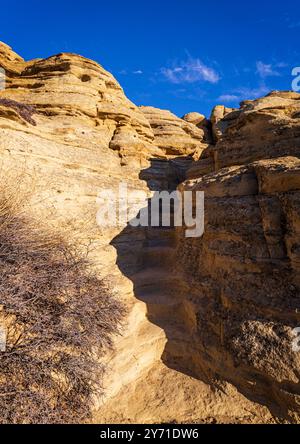 Der schmale Weg führt durch Sandsteinmauern, die an sonnigen Tagen zu Stufen führen Stockfoto